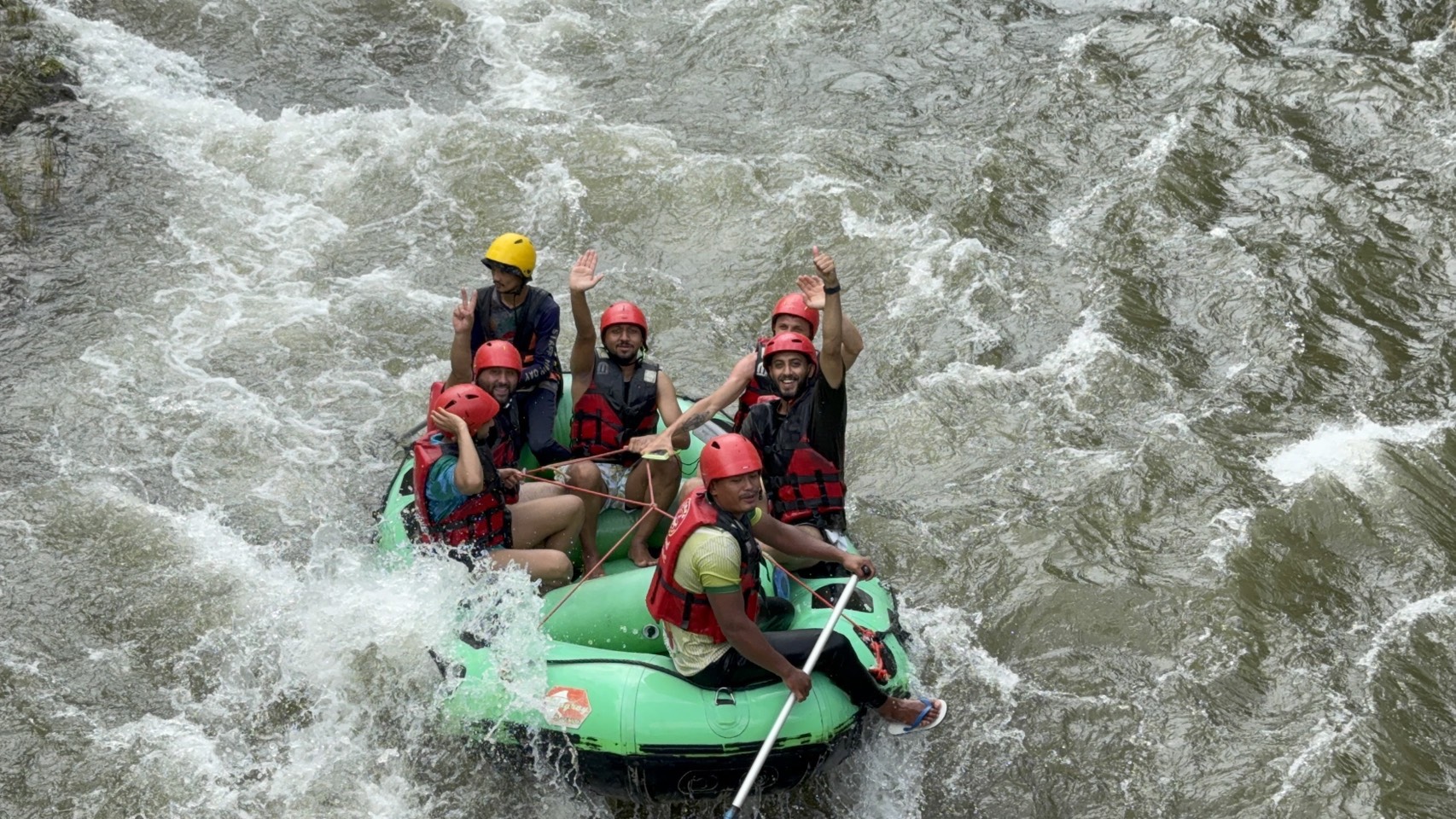 Rafting w zielonym pontonie na rwącej rzece