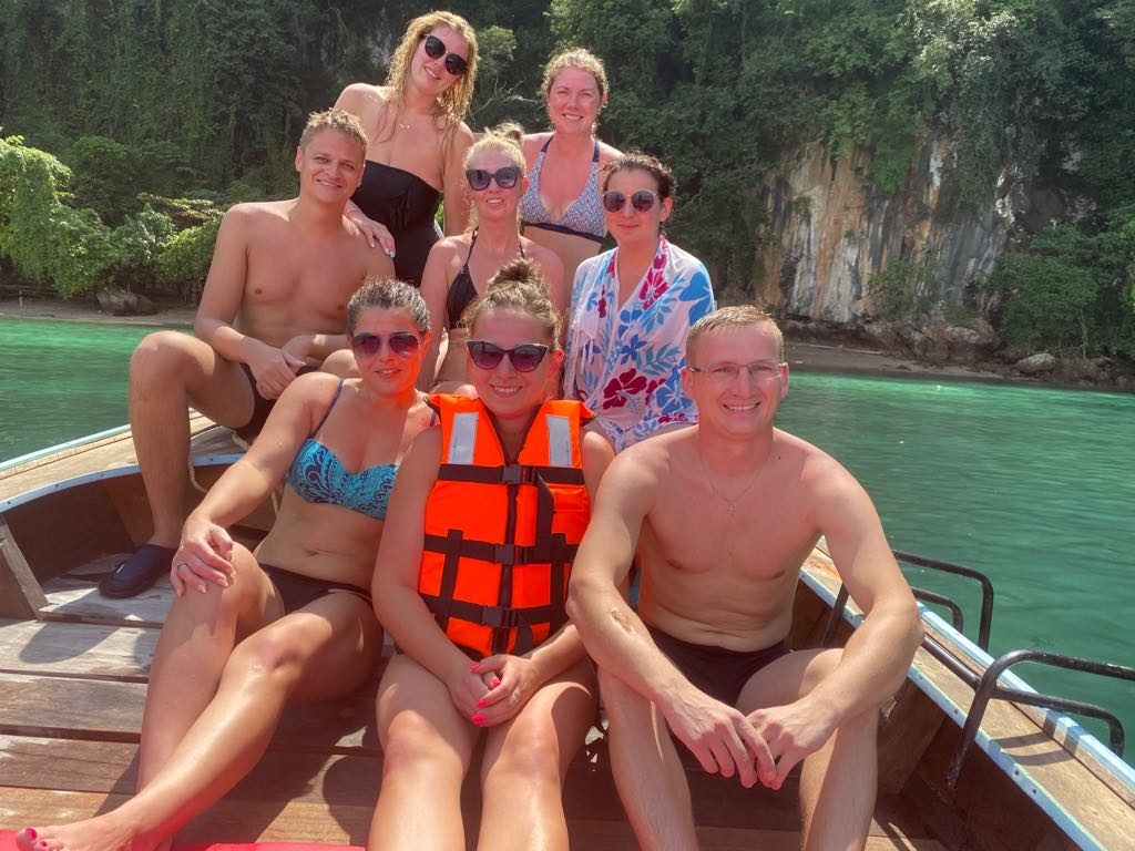 Łódź longtail z turystami płynąca między wapiennymi klifami w Krabi w grudniu