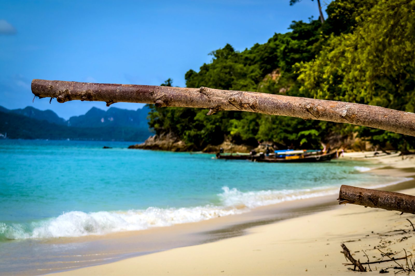 Plaża Bamboo Island z jasnym piaskiem i łodziami longtail niedaleko Phi Phi
